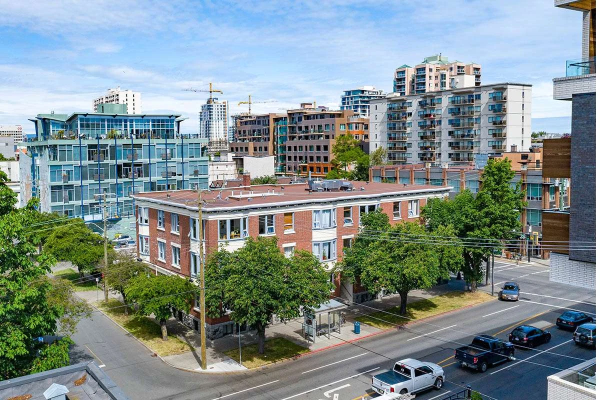Brick multi-family apartment building on a tree-lined city street